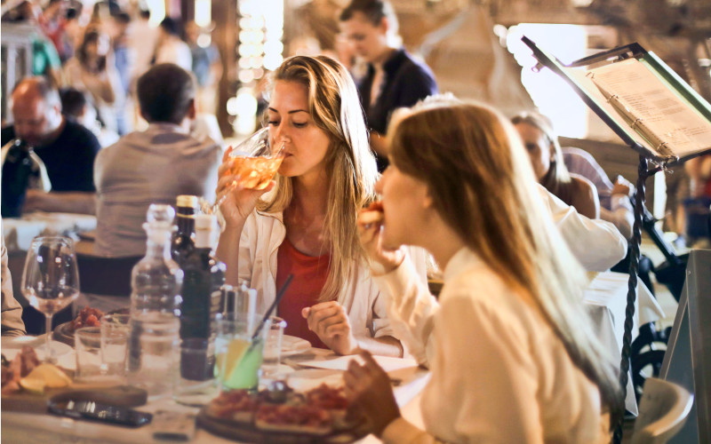 ragazze che bevono e mangiano al ristorante