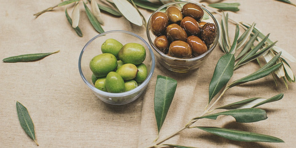 Due varietà di olive con foglia di olivo