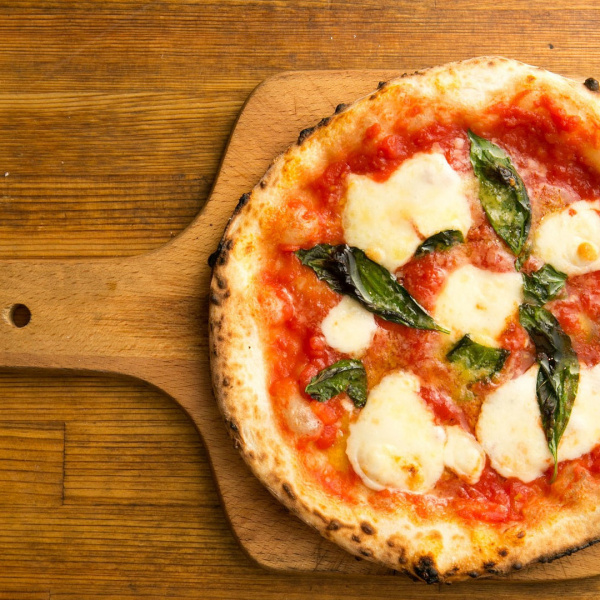 pizza margherita with tomato and mozzarella on cutting board