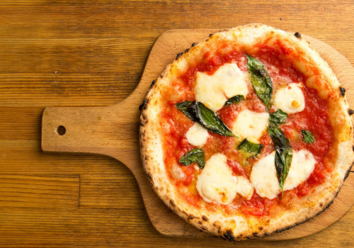 pizza margherita with tomato and mozzarella on cutting board