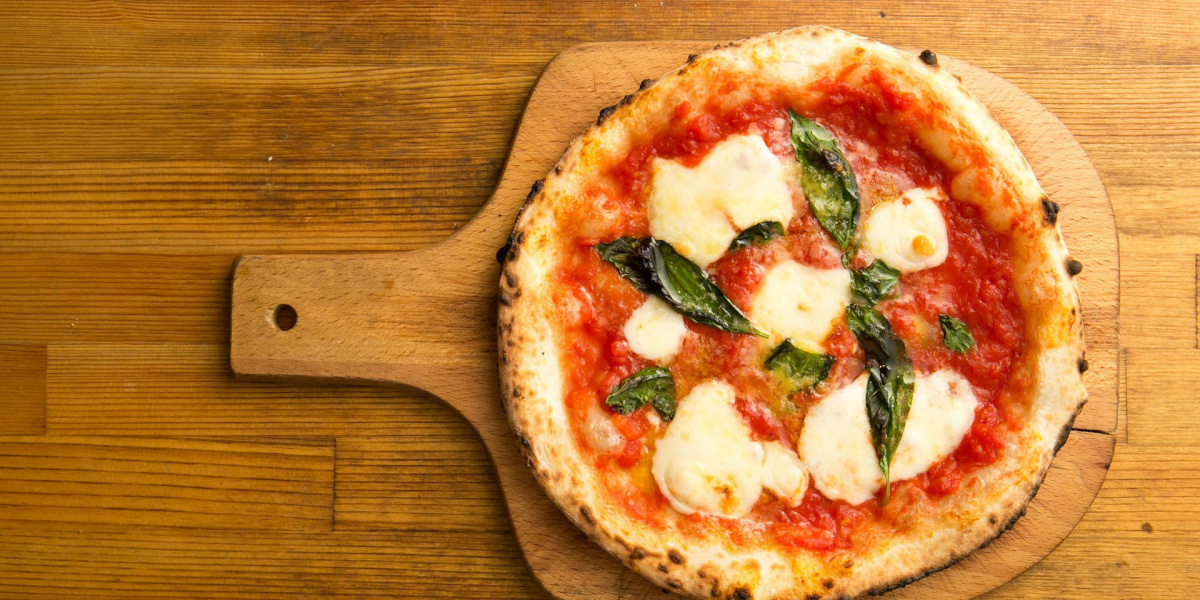 pizza margherita with tomato and mozzarella on cutting board