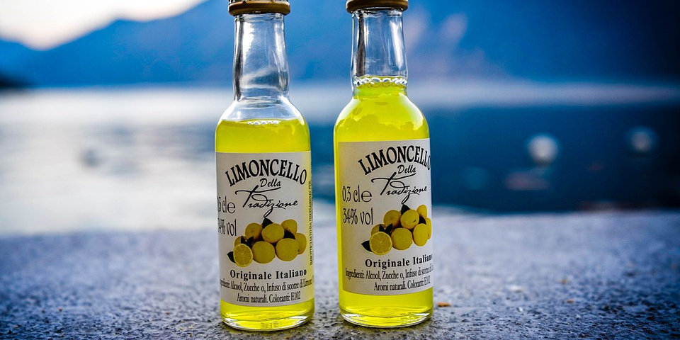 Bottigliette di limoncello con mare sullo sfondo